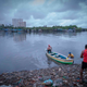 A fisherman tugs at a boat in Versova creek, Mumbai.